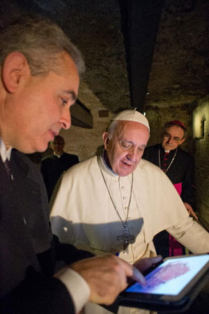Pope Francis looks at a photo of the graffito